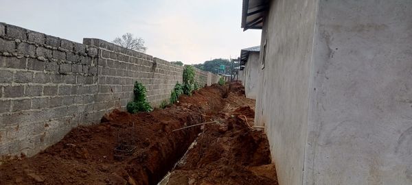 Service trench beside a housing unit and boundary wall